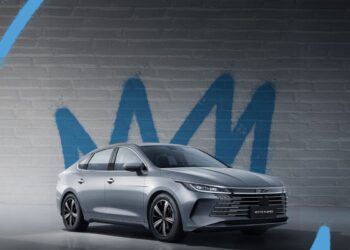 BYD King L sedã híbrido prata estacionado em frente a parede com grafite azul, mostrando design moderno e elegante do veículo chinês