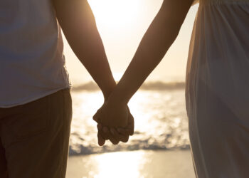 casal de mãos dadas na praia - dia dos namorados