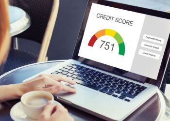 O 'CPF Nota 10': Como Funciona o Score de Crédito e o que Ele Realmente Diz Sobre Você (e Seus Hábitos) 4 Mulher consulta score de crédito positivo (751) em laptop com xícara de café ao lado.